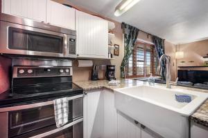 cocina con fregadero y microondas en Winter Park Meadows Lodge, en Fraser
