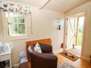 a living room with a chair and a window at Shepherd's Hut at Retreat in Llanrhaeadr-ym-Mochnant
