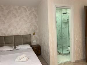 a bedroom with a bed and a glass shower at Appartament Home Plus in Tbilisi City