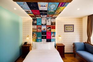 Limehouse Library Hotel في لندن: غرفة بسرير وجدار مغطى بالألبومات