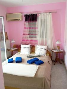 a bedroom with a bed with blue pillows on it at Trizinia view balcony in Galatas