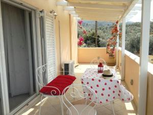 ein Zimmer mit Tisch und Stühlen auf einem Balkon in der Unterkunft Trizinia view balcony in Galatás