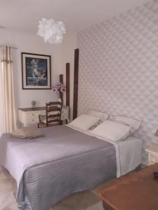 a bedroom with a large bed and a chair at les olivades in Magalas