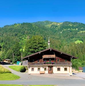 ein Gebäude mit einem Kreuz darüber in der Unterkunft Pension Obwiesen in Kirchberg in Tirol