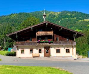 a building with a cross on top of it at Pension Obwiesen in Kirchberg in Tirol