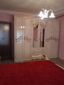 1 dormitorio con armario blanco grande y alfombra roja en casa vacanze zia Lina, 