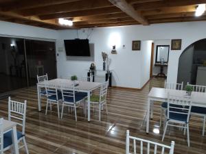 a dining room with white tables and chairs and a tv at San José Hotel Boutique & Spa in La Ligua