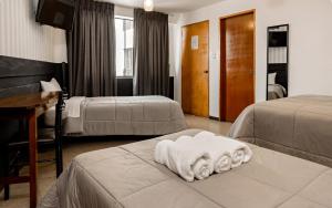 Habitación de hotel con 2 camas y toallas en la cama en Miraflores Suites Centro, en Lima