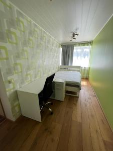 um quarto com uma cama, uma secretária e uma cadeira em Tallinna tn. 18 em Kuressaare