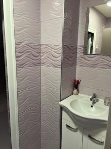 a bathroom with a sink and a mirror at Къща за гости ТАТЯНА / GUEST HOUSE TATIANA in Petrich +7 photos