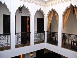 un edificio con paredes blancas y balcones ornamentados en Riad La Residenza, en Marrakech