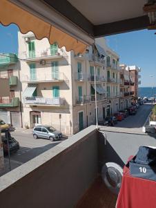 a balcony of a building with a car on the street at fronte mare in Giovinazzo