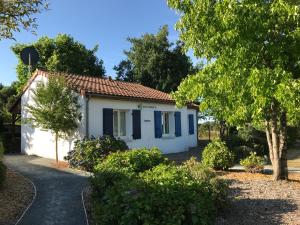 a small white house with blue windows and trees at French country home III in Les Forges