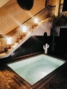 una piscina en medio de una habitación con una mesa en Riad La Residenza, en Marrakech