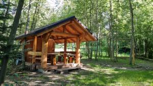um pavilhão de madeira numa floresta com árvores em Rezydencja Barrettski em Wisla