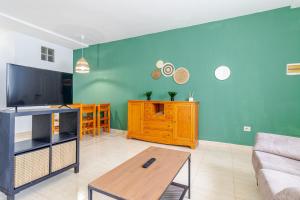 Il comprend un salon doté d'un canapé et d'une télévision à écran plat. dans l'établissement Flatguest Fuerteventura Airport, à Puerto del Rosario