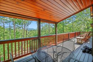 a screened in porch with a table and chairs on it at Bear Cloud in Blue Ridge