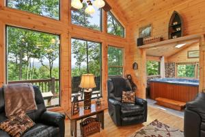a cabin living room with two chairs and a tub at Bear Cloud in Blue Ridge