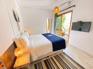 ein Schlafzimmer mit einem Bett und einem TV in einem Zimmer in der Unterkunft Pousada Pono Village in Juquei
