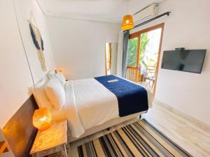 a bedroom with a bed and a tv in a room at Pousada Pono Village in Juquei