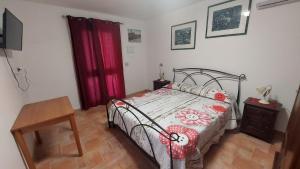 sypialnia z łóżkiem i czerwoną zasłoną w obiekcie Il Lentischio w mieście Cala Sapone