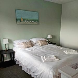 a bedroom with a large white bed with two pillows at 1 Bedroom House with Garden and off road private parking in Peterborough