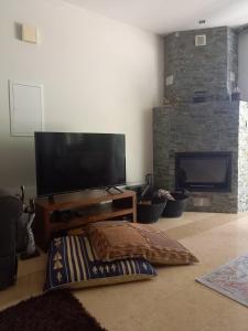 a living room with a flat screen tv and a couch at Glykoharama Cottage in Kalopanayiotis