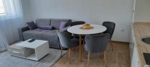 a living room with a table and chairs and a couch at Apartmani Sunlight in Vrnjačka Banja
