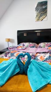 uma cama com duas toalhas em forma de coração em Blu Raj - domy w Sudetach em Głuszyca