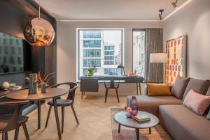 ein Wohnzimmer mit einer Couch und einem Tisch in der Unterkunft Andaz Munich Schwabinger Tor, By Hyatt in München