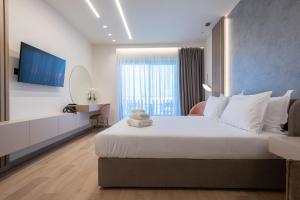 a bedroom with a large white bed and a television at GRAND PATELLI in Myrina