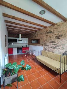a living room with a couch and a brick wall at Casa Dos Cregos in Bascuas