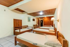 ein Zimmer mit drei Betten und einer Couch in der Unterkunft VOA Samuka Hotel in Florianópolis