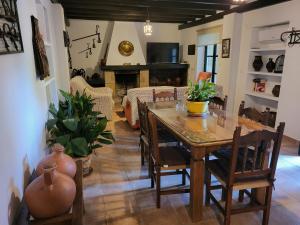 a dining room with a table and a living room at Casa Rural Casa del Tigre in Gaucín