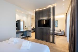 a room with a bed and a tv and a living room at GRAND PATELLI in Myrina