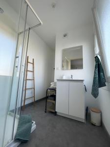 uma casa de banho com um lavatório, um espelho e uma escada em ATLANTIS em Saint-Nazaire