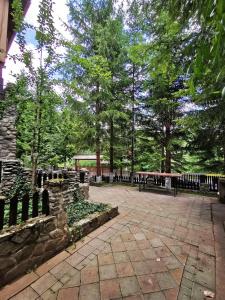 a patio with benches and trees in a park at Cabana Brazilor in Campina