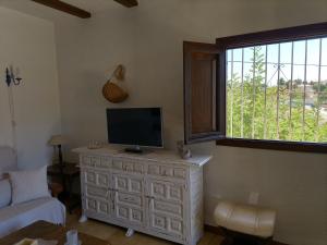 een woonkamer met een televisie op een dressoir bij Barlovento in La Canuta
