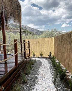 a wooden fence and a wooden walkway next to a fence at Lovin Göcek & Tiny House Lykia in Kertmeç
