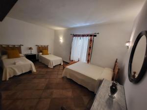 a hotel room with two beds and a mirror at Casa Rural Casa del Tigre in Gaucín