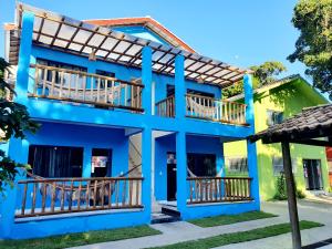 un edificio azul con balcones de madera en APARTAMENTOS DO BRUNO, en Arraial d'Ajuda