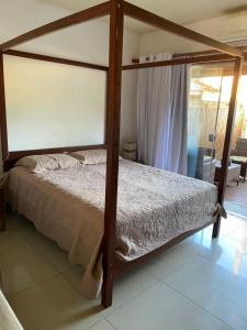 ein Schlafzimmer mit einem Himmelbett in einem Zimmer in der Unterkunft Flores do Mar in Arraial d'Ajuda