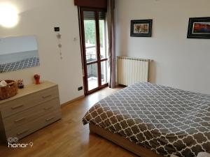 a bedroom with a bed and a dresser and a window at Appartamento Ca' Lela in Marghera