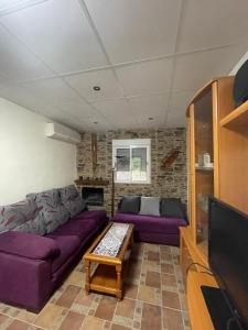 salon z fioletowymi kanapami i telewizorem w obiekcie La Casa del Rio w mieście Casabermeja