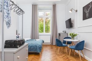 a bedroom with a bed and a table and chairs at Traveler's Best Choice - Old Town Guesthouse - by Upstairs in Kraków