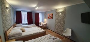 pokój hotelowy z dwoma łóżkami i telewizorem w obiekcie Villa Eden & Restaurant w mieście Ełk