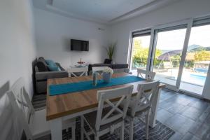 a dining room and living room with a table and chairs at Villa Kula in Bihać