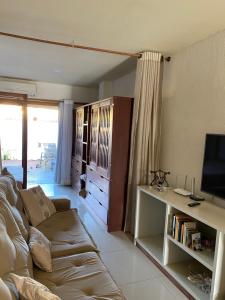 ein Wohnzimmer mit Sofa und Fernseher in der Unterkunft Flores do Mar in Arraial d'Ajuda