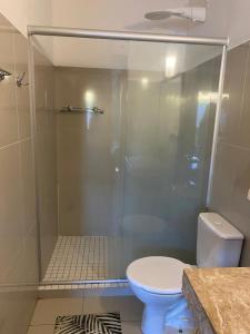 ein Badezimmer mit Glasdusche und Toilette in der Unterkunft Flores do Mar in Arraial d'Ajuda + 17 Fotos