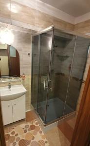 a glass shower in a bathroom with a sink at Villa Eden & Restaurant in Ełk